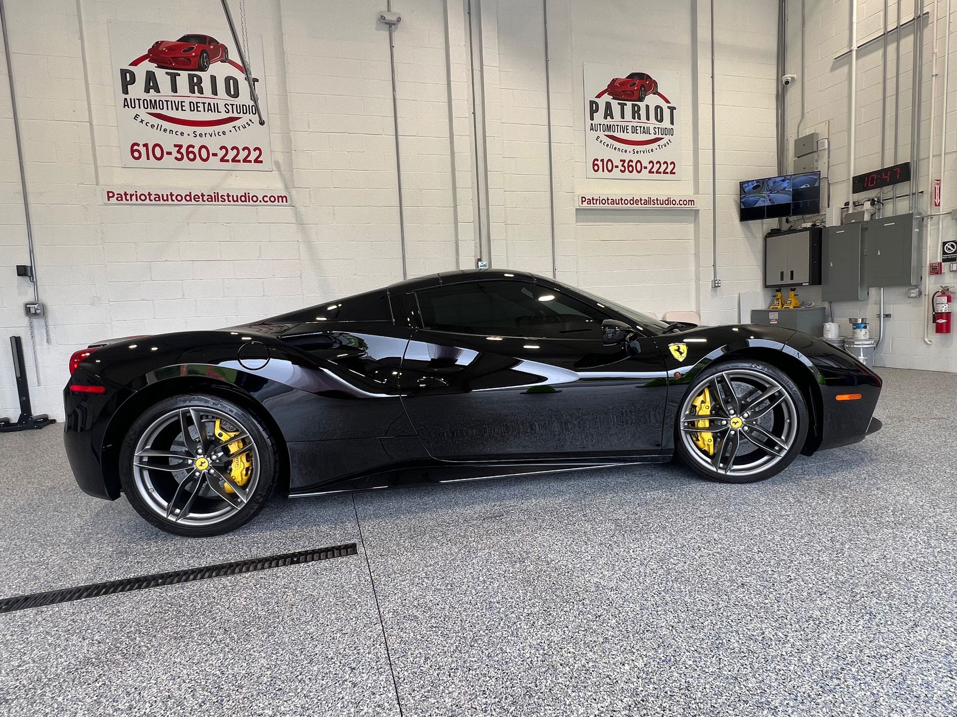 Sleek black luxury car in a dark studio with headlights on